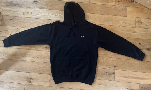 Black hoodie laid flat on wooden floor, ideal for those looking to unlock fitness potential steps