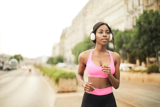 Woman jogging in a sports bra and headphones, illustrating how to start a jogging routine