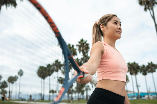 Beginner tennis guide showcasing a female player ready to serve on an outdoor court