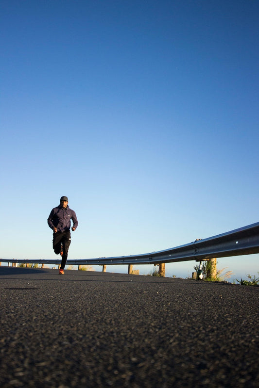 Runner on a scenic road demonstrating effective running performance tips for better training