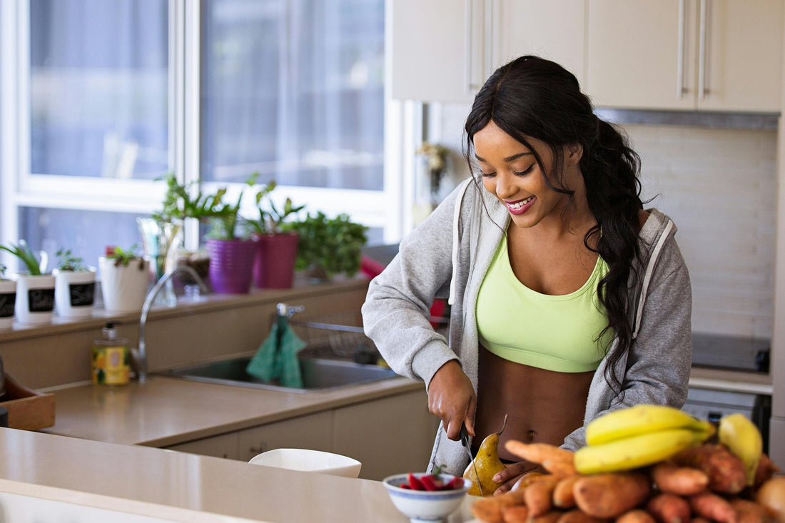 Woman preparing healthy meals in kitchen, emphasizing nutrition for fitness and a balanced diet