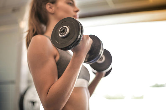 Woman lifting dumbbells at the gym illustrating a beginner's guide to creatine for fitness