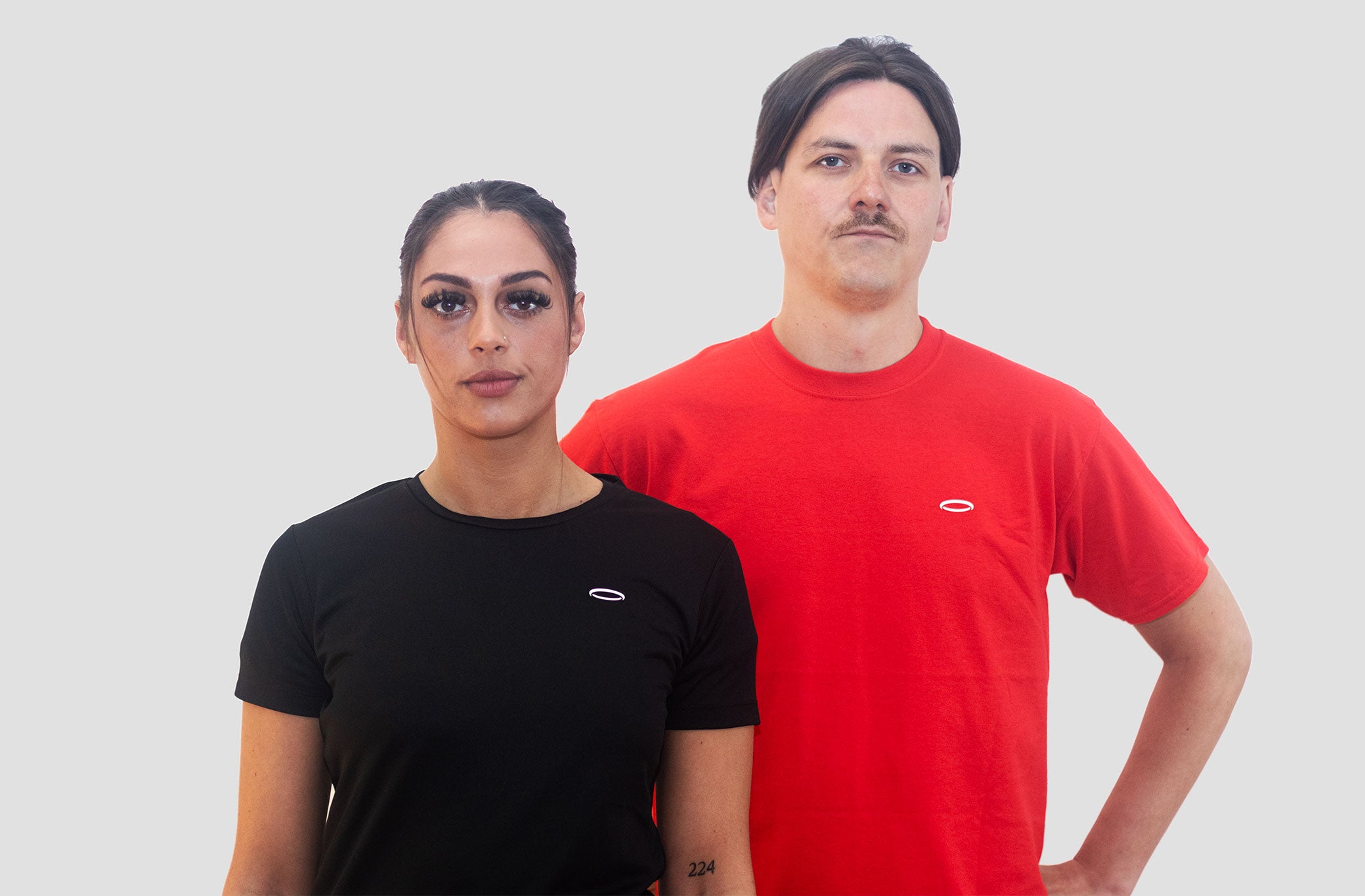 A couple wearing Bodydisciple halo t-shirts red and black, looking to the at the camera