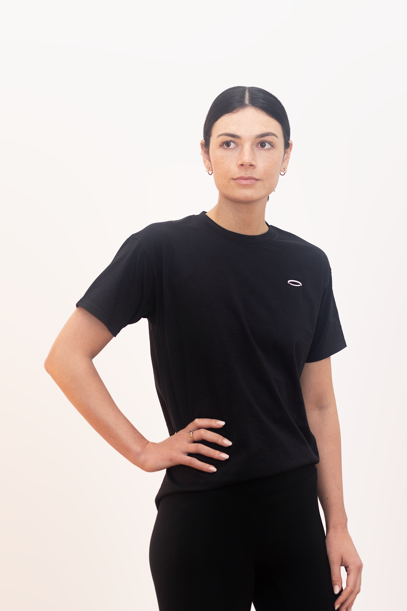 Model wearing a Women's Black Halo Tee with a comfortable fit and subtle logo detail
