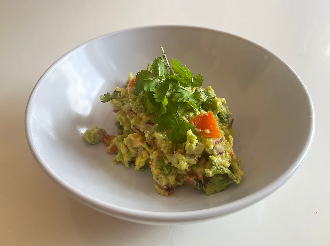 Delicious bowl of healthy guacamole recipe with fresh ingredients and cilantro garnish