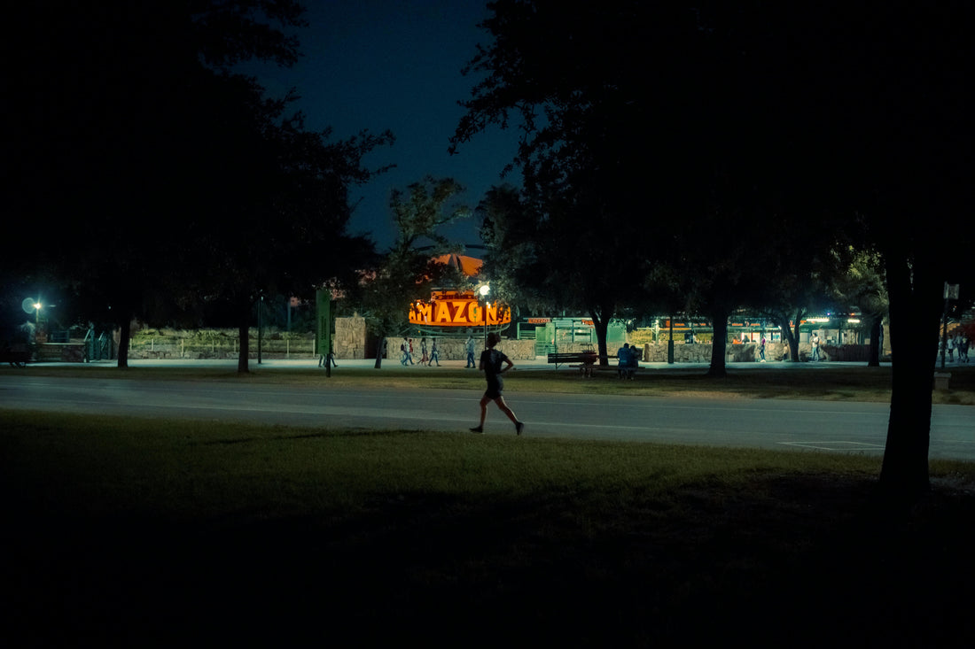 A runner jogging at night in a park, emphasizing night running safety tips for visibility and safety