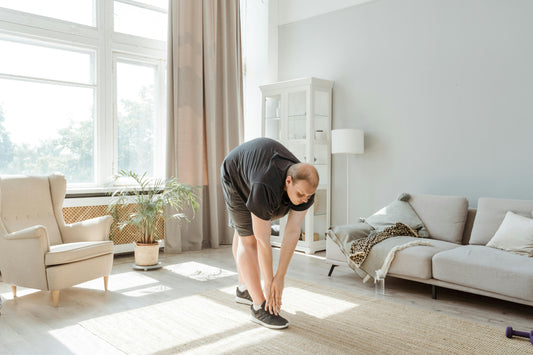 Person performing a stretch during indoor workout routines for beginners in a bright living room