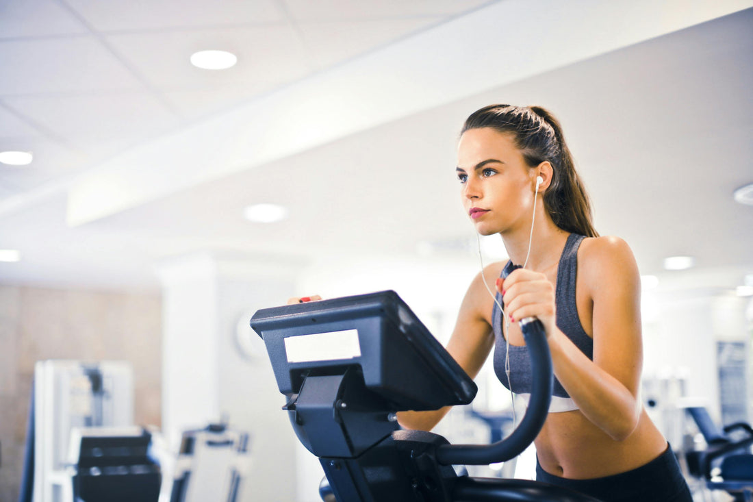 Young woman exercising on an elliptical machine, following gym safety tips for beginners