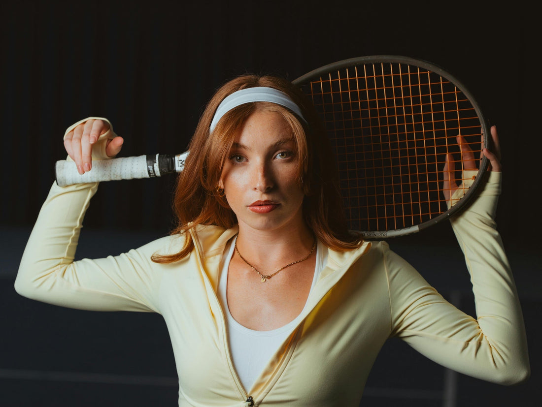 Female tennis player showcasing the benefits of starting tennis later in life with a racket ready for play