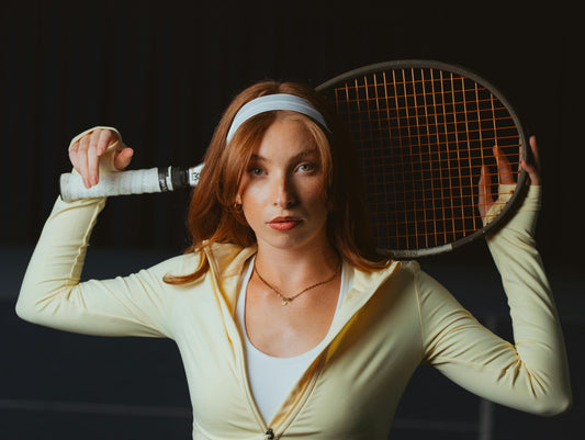 Female tennis player showcasing the benefits of starting tennis later in life with a racket ready for play