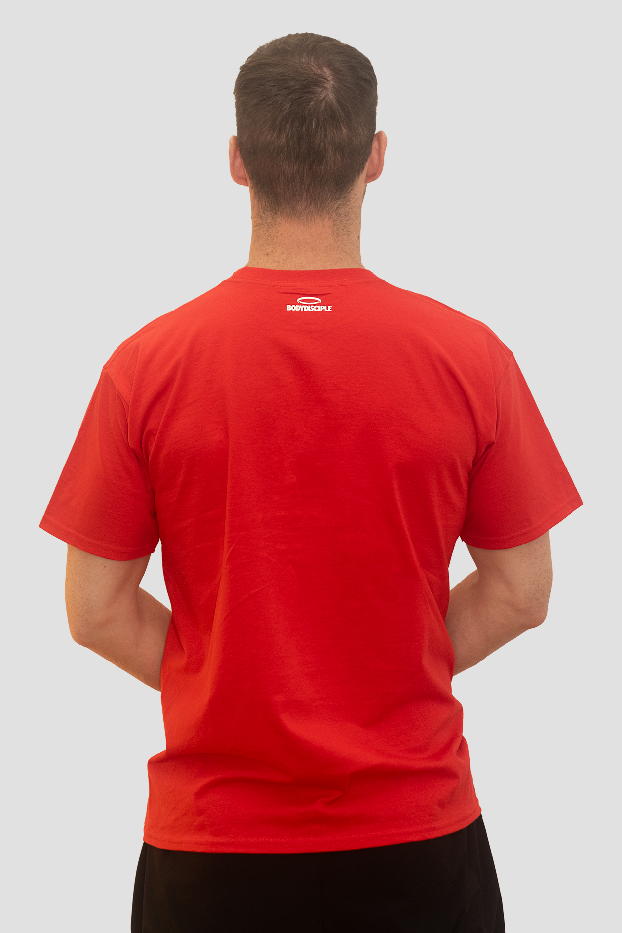 Man facing away from the camera wearing  a red Bodydisciple tee