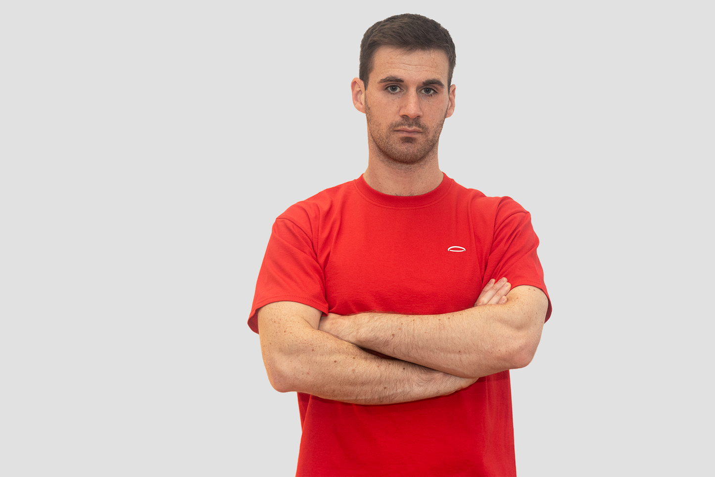 A young man wearing a red Bodydisciple halo tee, looking at the camera