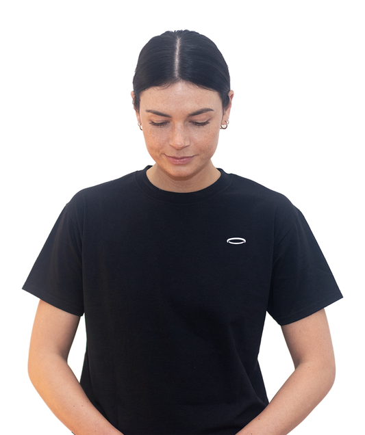 A woman, looking down, wearing a Bodydisciple black tee B24D302BLK_Women_1