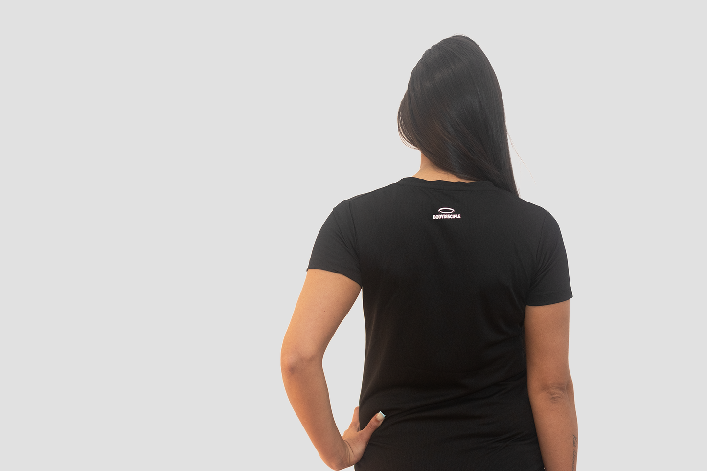 A woman, looking away, wearing Bodydisciple drift t-shirt B24D521BLK_Women_1